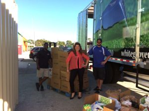 Anna Valencia Tillery, host of The Vero Insider, proudly showing off over 3 pallets of food with some of the White Glove Moving team.